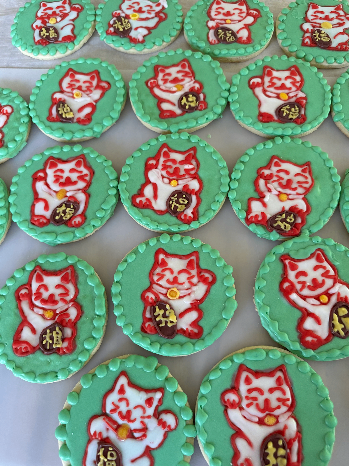 Lucky cat (maneki-neko) cookies with green borders and red detailing